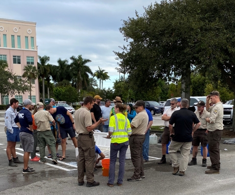 A group of fish biologists representing 11 agencies and universities assessing their non-native catch in a mall parking lot in Miami, FL.