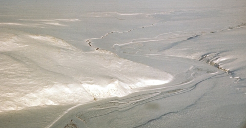 a snow scene showing topography including hills and a river from an aerial view