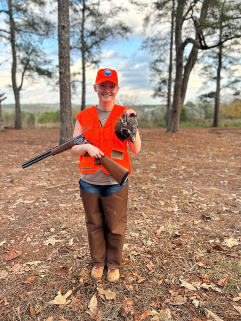 ACE Fellow Elena Campbell wearing blazing orange holds three quail she successfully harvested while hunting at Buckeyes Plantation. 