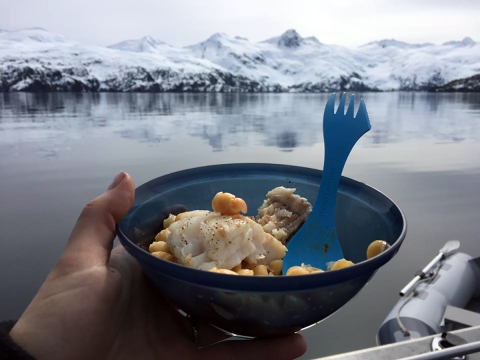 a bowl of food with ocean and mountains in the background