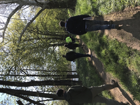 Group of people walking along stream.