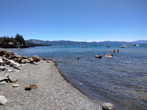 Shoreline of Lake Tahoe with boats in the distance
