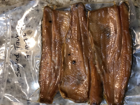 Smoked fish fillets in a clear vacuum sealed bag. The bag is dated 7–10–22.