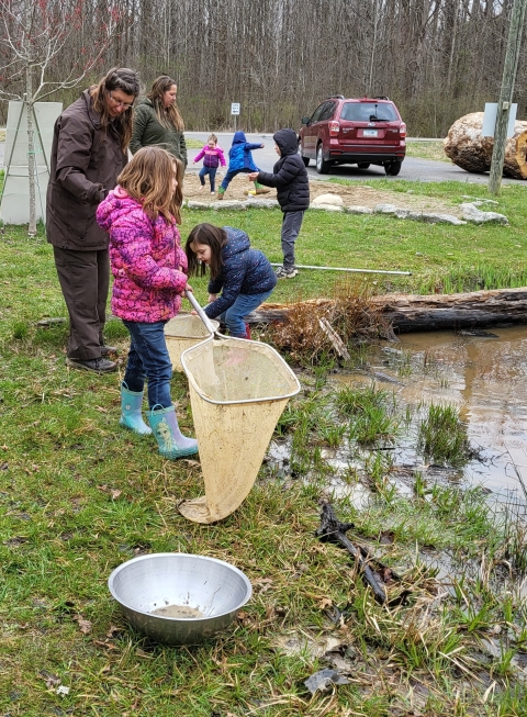 Children with dip nets by pond