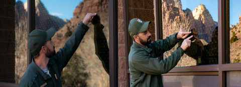 National Park Service employee applies exterior bird-friendly window treatment at Zion National Park building