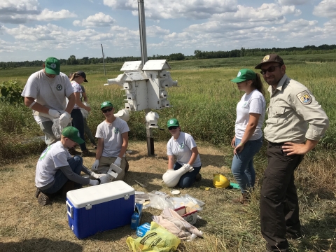 YCC Participants gathered around a purple martin house, checking nests.
