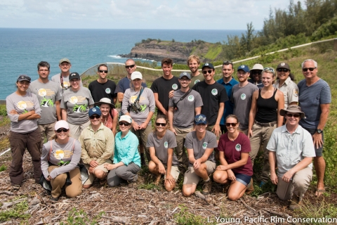 Volunteers and staff from the Kauaʻi Endangered Species Recovery Project stand near the predator proof fencing.