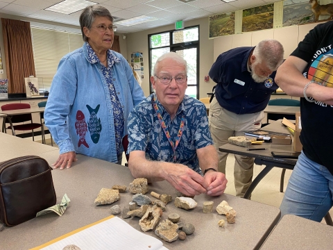 Professor examining fossils in a classroom