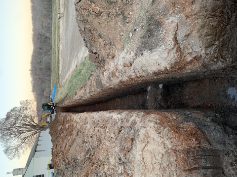 A trench being dug by an excavator for new pipelines at Mammoth Spring national Fish Hatchery.