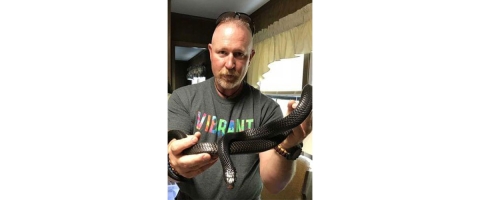 Tony Brady, deputy project leader at Welaka National Fish Hatchery poses with an Eastern indigo snake.