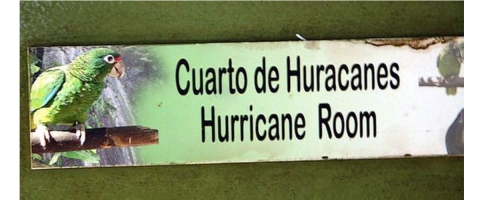 Entrance to the concrete room designed to withstand hurricane force winds. A graphic, with a Puerto Rican parrot featured, that says Hurricane Room.