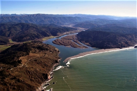 river flowing into ocean surrounded by hills