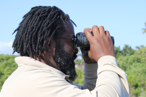 A man looking through a pair of binoculars