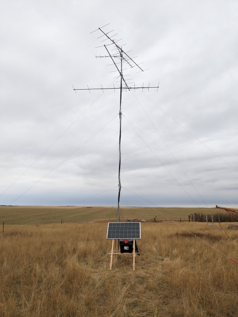 Motus tower in a grassland with a solar panel