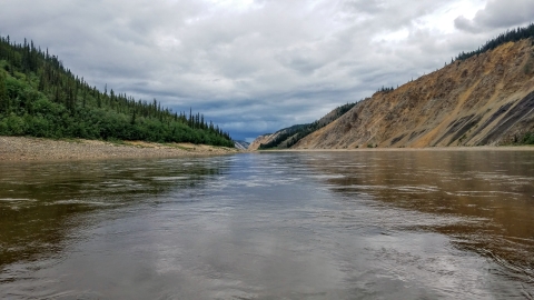 A water level landscape of a river with bluffs and forest on each side
