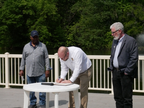 Scott Kahan signs the Hartford Urban Bird Treaty alongside two of the partnership partner representatives