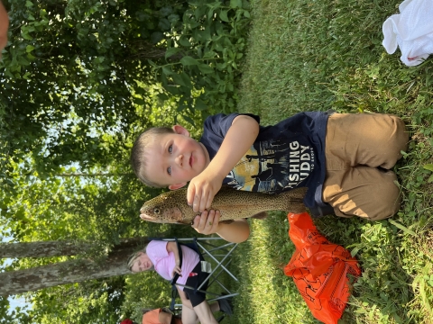 Photo of young angler holding the rainbow trout he caught during the Wolf Creek National Fish Hatchery Catch-a-Rainbow derby.