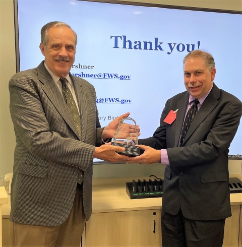 Stephen Guertin, Deputy Director for Program Management and Policy, USFWS (Left) presents award to and U.S. Coast Guard Delaware Bay Awardee Dr. Brian Washburn, Research Wildlife Biologist with USDA APHIS Wildlife Services (Right) 