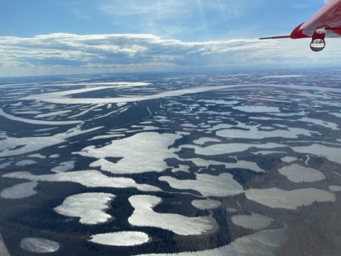 view from an airplane of wetlands and a large river across the landscape