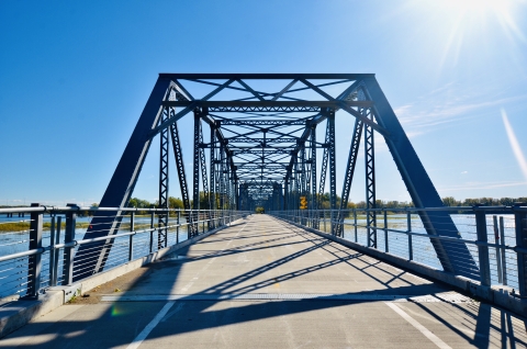 front view of a pedestrian, multi-span truss bridge on a sunny day