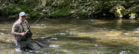 A man fishes in a river.