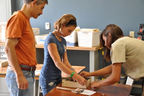FWS employee helps Refuge visitors build bird feeders.