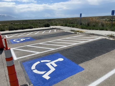 corner of parking lot showing accessible parking and other striping. Beyond is the refuge.