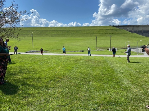 Group of people practicing casting flies in a field 