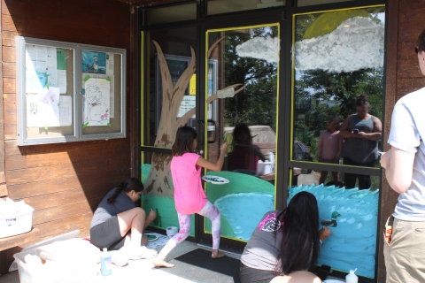 Children paint on the doors of a visitor center