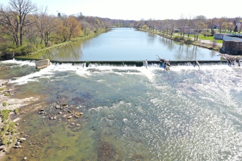 The before image shows the low-head dam with some woody debris on it and a high-water level before the dam. There is very little exposed riverbed.