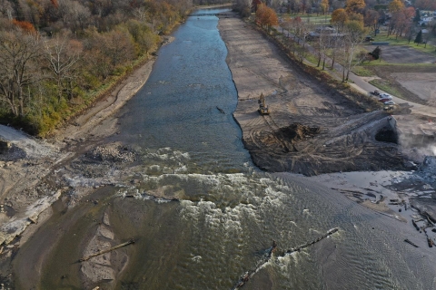 The after image, right after construction, shows a free-flowing river with sediment on either side. The old coal plant has also been removed. 