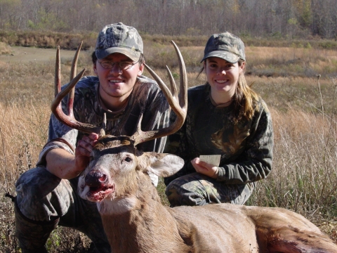 A pair of local hunters with a harvested 8-point buck.