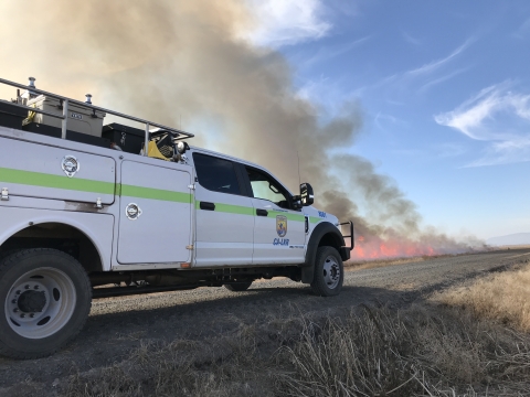 Type 6 Fire Engine with prescribed fire in the background