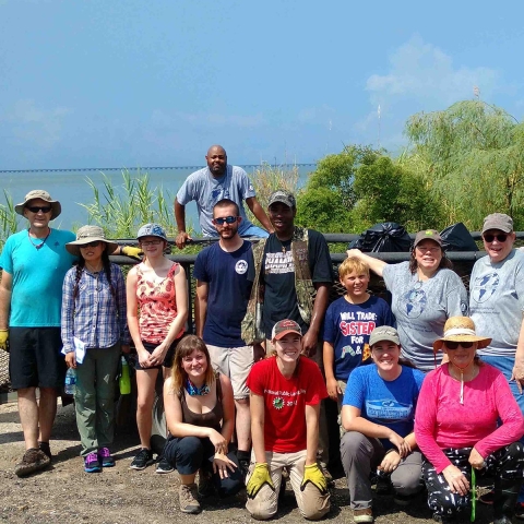 Group of women, men and children on short of Lake Pontchartrain at litter clean up 