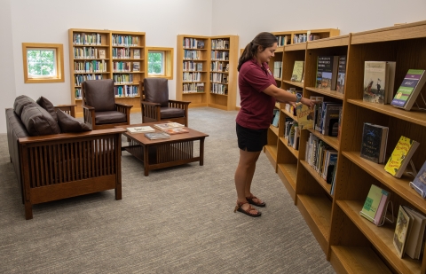 Library visitor selects a book from the shelf at USFWS Library