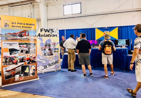 Migratory Bird Program Assistant Director Jerome Ford with Staff at EAA AirVenture Convention booth interacting with the public