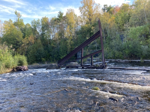 a large A-shaped steel frame juts out of a river