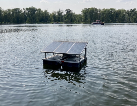 Platform with solar panel on it floating in water.