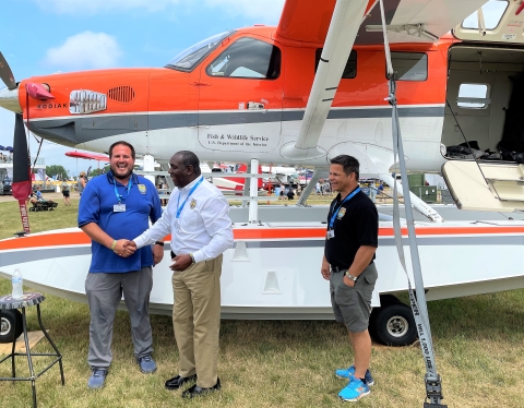 Garrett Wilkerson and Jerome Ford shaking hands and smiling by the survey plane with Scott Bishaw