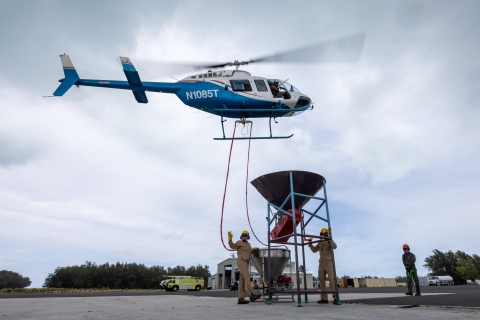 A helicopter is hoisted to a mixer for rodenticide. 