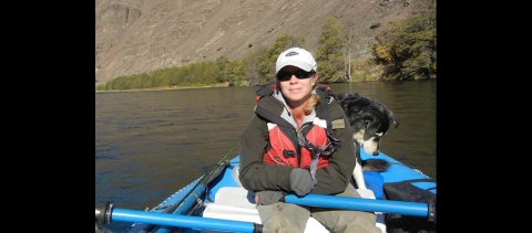A woman in a hat and sunglasses sits in a kayak