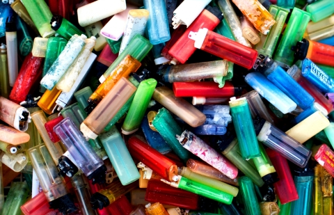 A large pile of multi-colored plastic cigarette lighters