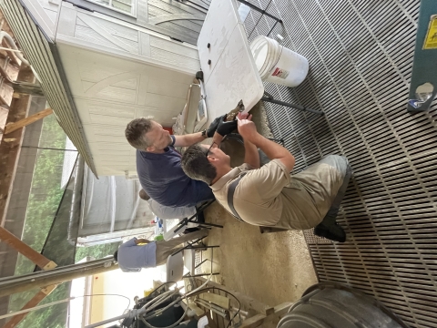 William helps biochemist take a blood sample from a rainbow trout.