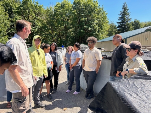 pic 7 of Interns Suzena Arias, Mee-ya Monneedy and Izaiah McQueen and other interns standing outdoors at Abernathy Fish Technology Center in Washington.
