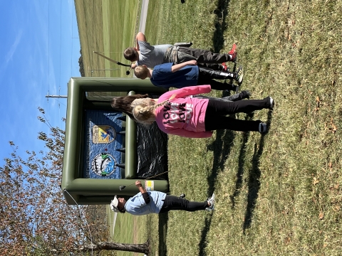 Kids shooting archery at a blow up target