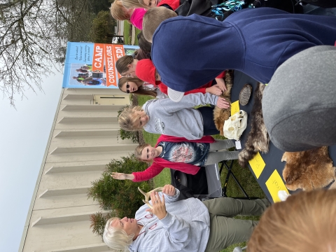 Kids standing by a booth of furs and skulls 