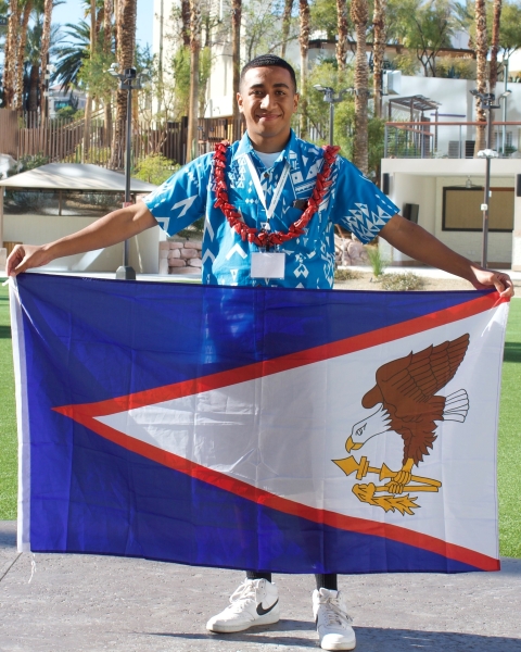  Person wearing leis and holding the flag of American Samoa 