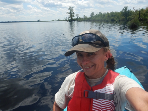 A selfie of a woman floating in a kayak on Lake Drummond in Great Dismal Swamp National Wildlife Refuge.