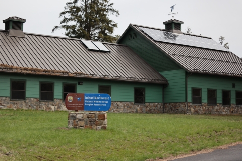 A brown and blue sign that reads "Inland Northwest National Wildlife Refuge Complex Headquarters"