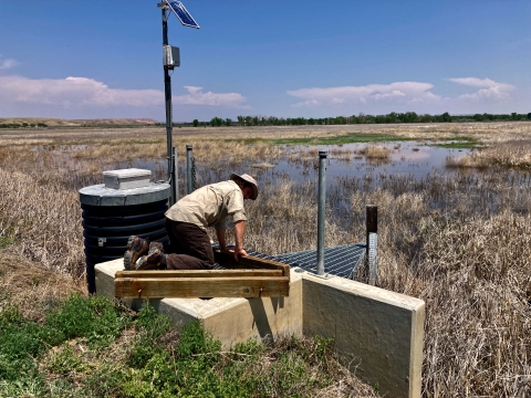 Ouray NWR employee inserting boards into a water control structure